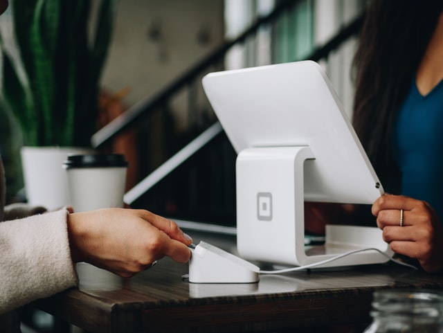 A hand making a payment with a credit card